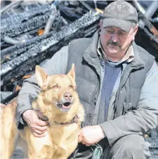  ??  ?? Bob Bennett with Moxxi, a seven-year-old Belgian shepherd mixed breed that likely saved his life Monday afternoon by barking and alerting him to a fire in his garage while he worked underneath a car.