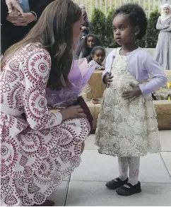  ?? ANDREW MILLIGAN / POOL / GETTY IMAGES ?? Catherine, Duchess of Cambridge, receives flowers from a young girl during a visit to the Immigrant Services Society of British Columbia’s new welcome centre.