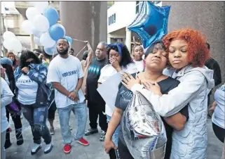  ?? [SAM UPSHAW JR./ COURIER JOURNAL VIA USA TODAY NETWORK] ?? Tamika Palmer, left, is embraced by her daughter, Juniyah Palmer, on March 19 during a vigil for her other daughter, Breonna Taylor, outside the Judicial Center in downtown Louisville, Ky. Taylor was killed by a police officer.