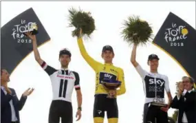  ?? CHRISTOPHE ENA — THE ASSOCIATED PRESS ?? Britain’s Geraint Thomas, wearing the overall leader’s yellow jersey, second place Netherland­s’ Tom Dumoulin, left, and third place Britain’s Chris Froome, right, celebrate on the podium after the 21st stage of the Tour de France cycling race over 72.1...