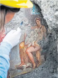  ??  ?? An archaeolog­ist cleans up the fresco Leda E Il Cigno ( Leda And The Sawn).