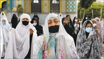  ?? Ebrahim Noroozi Associated Press ?? IRANIAN worshipers observing COVID-19 pandemic guidelines offer Eid al-Fitr prayers in May in Tehran.