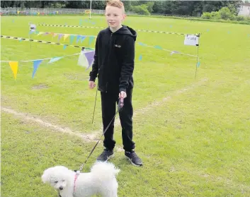  ??  ?? Standing to attention This excited young lad expertly handled his Bischon Frise Rosie