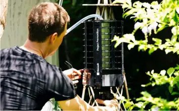  ??  ?? TRAP. Microsoft researcher Ethan Jackson sets up a trap for mosquitoes in Harris County, Texas in 2016. A new high-tech version trap is promising to catch the bloodsucke­rs while letting friendlier insects escape, and even record the exact weather...