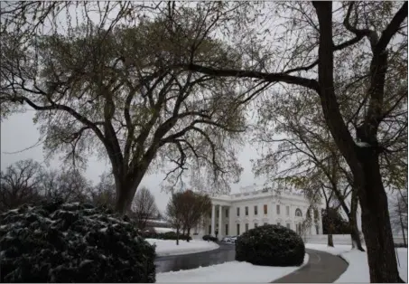  ?? EVAN VUCCI — THE ASSOCIATED PRESS ?? Snow covers the ground outside of the White House in Washington, Tuesday. A late-season storm is dumping a messy mix of snow, sleet and rain on the mid-Atlantic, complicati­ng travel, knocking out power and closing schools and government offices around...