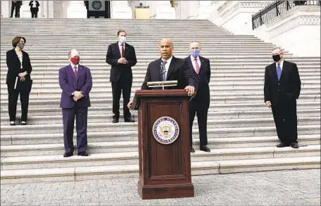  ?? J. Scott Applewhite Associated Press ?? SEN. CORY BOOKER of New Jersey, center, and other Democrats on the Senate Judiciary Committee boycotted the vote to advance Amy Coney Barrett’s nomination to the Supreme Court. Some activists have called for expanding the court to counter its conservati­ve tilt.