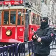  ??  ?? A tram is driven past as a Turkish police officer secures central Istanbul’s Istiklal Avenue, the main shopping road of Istanbul.