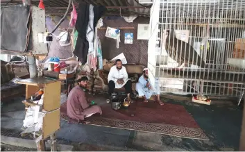  ??  ?? Afghani fishermen take a break as they weave cages used for fishing in the United Arab Emirates in eastern coastal town of Kalba. — AFP photos by Karim Sahib