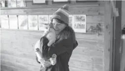  ?? MARCUS OLENIUK/TORONTO STAR ?? Lorena Rossi cuddles one of about 20 stray cats at Martinwood­s Farm in Caledon.