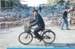  ??  ?? BEIJING: A man cycle past buildings which were destroyed by the municipali­ty on the outskirts of Beijing. —AFP