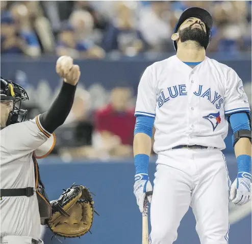  ?? MARK BLINCH / THE CANADIAN PRESS ?? Toronto Blue Jays’ Jose Bautista reacts to striking out against the Baltimore Orioles as Matt Wieters throws around the horn during the fourth inning of the Orioles’ 4- 0 win in Toronto on Thursday.