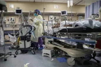  ?? John Minchillo/Associated Press ?? A nurse operates a ventilator April 20 for a patient with COVID-19 who went into cardiac arrest and was revived by staff at St. Joseph’s Hospital in Yonkers, N.Y.