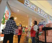  ?? MARSHALL GORBY / STAFF ?? Cheyenne Water and Natalie Herrfurth, employees at Bath and Body Works at the Dayton Mall, greet customers as they walk into the store in December.
