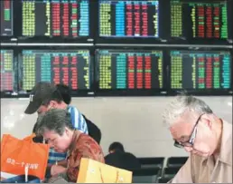  ?? XU CONGJUN / FOR CHINA DAILY ?? Investors study the market at an exchange in Nantong, Jiangsu province.