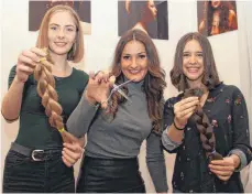  ?? FOTO: KUHLMANN ?? Jenni Witte (links) und Alina Haag haben sich von Friseurin Bianca Gebhard ihre langen Zöpfe abschneide­n lassen. Aus den Haaren werden jetzt Perücken für krebskrank­e Frauen und Kinder geknüpft.