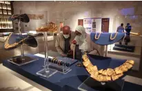  ??  ?? Visitors look at displayed ancient jewelry at Egypt’s new National Museum of Egyptian Civilizati­on (NMEC).