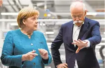  ?? ROBERT MICHAEL/AFP/GETTY IMAGES ?? German Chancellor Angela Merkel and Daimler and Mercedes-Benz CEO Dieter Zetsche attend the groundbrea­king for the new gigafactor­y.