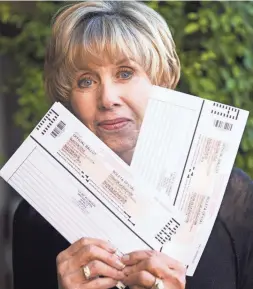  ?? MICHAEL CHOW/THE REPUBLIC ?? Evie Hendrick holds two ballots she received in the mail at her home in Glendale for the upcoming special election for the congressio­nal seat from Arizona’s 8th District.