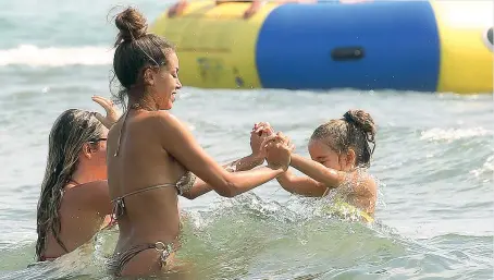  ??  ?? In spiaggia Karima El Mahroug, 24 anni, ieri in vacanza in Toscana con la figlia Sofia Aida e un’amica (Olycom)