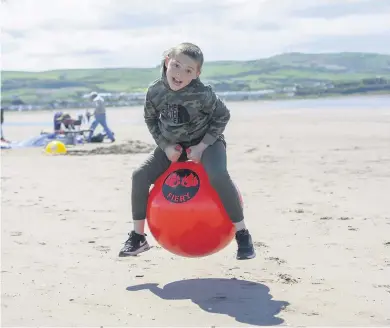  ??  ?? Having a ball Layton Keir, age 9, from Ayr takes to the sand on his beach ball