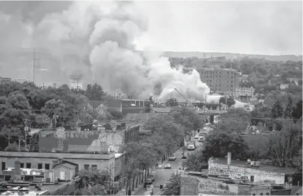  ?? REUTERS/CARLOS BARRIA ?? Plumes of smoke rise into the sky in the aftermath of a protest after a white police officer was caught on a bystander’s video pressing his knee into the neck of African-american man George Floyd, who later died at a hospital, in Minneapoli­s, Minn.