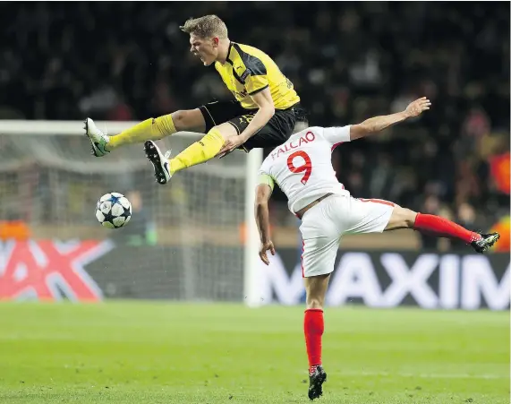  ?? — GETTY IMAGES ?? Borussia Dortmund defender Matthias Ginter, left, collides with Monaco forward Radamel Falcao during their second-leg Champions League quarter-final Wednesday at Stade Louis II in Monaco. Monaco won 3-1 to advance 6-3 on aggregate.