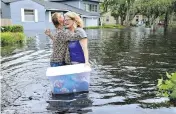  ?? DEDE SMITH / THE FLORIDA TIMES-UNION VIA AP ?? Florida residents wade through the streets of Jacksonvil­le, top and above, while boats are strewn around a Key Largo canal, right.
