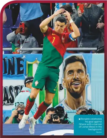  ?? ?? ■ Ronaldo celebrates his goal against Ghana with a banner of Lionel Messi in the background.