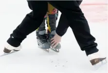  ??  ?? First-time skaters cling to the boards during a skating lesson on the holiday ice rink at Union Square. The free lessons will be held weekend morning until the rink closes in January. Instructor Deborah Davis helps a novice skater with foot placement...