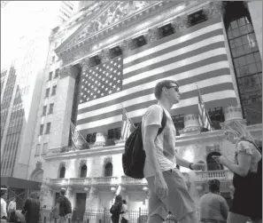  ?? Bloomberg News/JOHN TAGGART ?? Pedestrian­s pass an American flag in front of the New York Stock Exchange last month. Stocks rose Wednesday, pushed higher by health-care and industrial companies.