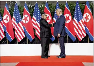  ?? DOUG MILLS / THE NEW YORK TIMES ?? North Korea’s Kim Jong Un and President Donald Trump greet each other before Tuesday’s talks in Singapore. A joint statement said the two nations would hold “follow-on negotiatio­ns” soon.