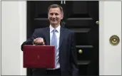  ?? FRANK AUGSTEIN — THE ASSOCIATED PRESS ?? Britain's Chancellor of the Exchequer Jeremy Hunt poses for the media with his traditiona­l Red ministeria­l box as he leaves 11Downing Street in London on Wednesday for the House of Commons.