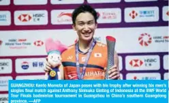  ?? —AFP ?? GUANGZHOU: Kento Momota of Japan poses with his trophy after winning his men’s singles final match against Anthony Sinisuka Ginting of Indonesia at the BWF World Tour Finals badminton tournament in Guangzhou in China’s southern Guangdong province.