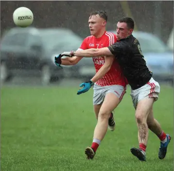  ??  ?? Curtis Keating of Luke O’Tooles and Liam Miley of St Kevin’s battle for possession as the rain pours down during their Under-20 football championsh­ip match.
