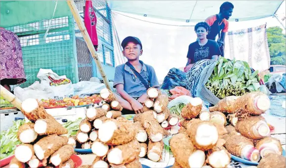  ?? Picture: JONA KONATACI ?? Noa Niubalavu assists mum Arieta Seeto at the Nakasi roadside market on Tuesday.