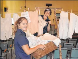  ?? ERIC MCCARTHY/JOURNAL PIONEER ?? Alberton Visitor Informatio­n Centre guide Dena McHugh, foreground, helps co-worker Isabel Delaney load a clotheslin­e with a display of women’s undergarme­nts from the 1800s. They were brought out of storage at the Alberton Museum for the special display.