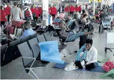  ?? DANIEL LEAL-OLIVAS/GETTY IMAGES ?? A passenger rests on the floor at London’s Heathrow Airport on Monday. Passengers faced a third day of disruption at Heathrow Monday as British Airways cancelled short-haul flights after a global computer crash.