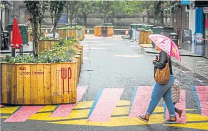  ?? Picture: Mhairi Edwards. ?? A family with a matching umbrella wanders past the newly painted surface on Union Street.