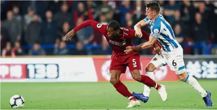  ?? — Reuters ?? Let go of me!: Liverpool’s Georginio Wijnaldum vying for the ball with Huddersfie­ld’s Jonathan Hogg.