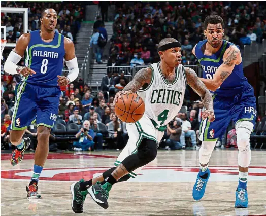  ??  ?? Back off: Boston Celtics’ Isaiah Thomas (centre) dribbling past Atlanta Hawks’ Thabo Sefolosha (right) during their NBA game at the Philips Arena on Friday. The Celtics won 103101. — AFP