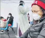  ?? Irfan Khan Los Angeles Times ?? ADA GOMEZ, 59, suffering from low fever, cough and a sore throat, waits at a COVID-19 screening station at the Watts Health Center in Los Angeles.