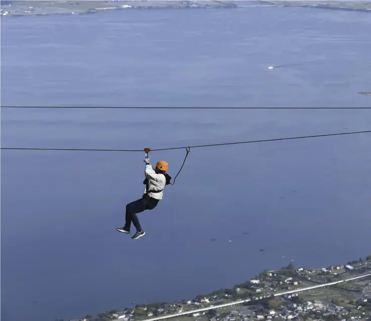  ?? ?? Yomiuri Shimbun photos
Visitors ride the Zip Line Adventure attraction.