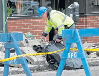  ?? NANCY LANE PHOTOS / BOSTON HERALD ?? AFTERMATH: Workers, left and above, pick up the pieces yesterday of the collapsed building facade on Harvard Avenue.