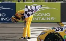  ?? AP ?? MOVING M&M’S: Kyle Busch takes a bow with the checker flag after winning a NASCAR Cup Series race at Pocono Raceway in Long Pond, Pa., on Sunday.