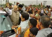  ?? — PTI ?? BJP president Amit Shah is greeted by party workers at Rajnagar Extension in Ghaziabad on Sunday while he was on his way to Meerut to attend the BJP’s state working committee meeting.