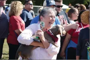  ?? (NWA Democrat-Gazette/Bennett Horne) ?? Donna Fallin, of Bella Vista, carries her dog Ozzie and the trophy he won Oct. 1 for finishing first in one of the races during the Wiener vs. Corgi Races in Bella Vista.