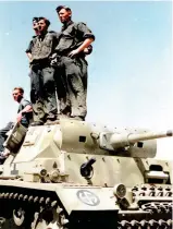  ?? ?? The crew of a Pz.Kpfw.III standing on their vehicle in a field. Note the Wiking insignia