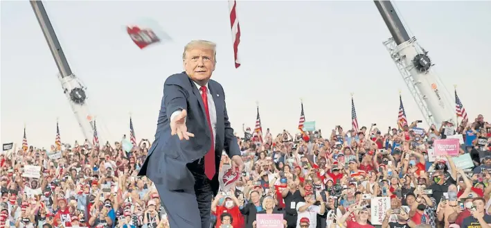  ?? REUTERS ?? Llegada. Ante la euforia de sus simpatizan­tes, el presidente Donald Trump arroja un barbijo a la multitud. Fue ayer, al inicio de su acto de campaña en Sanford, Florida.
