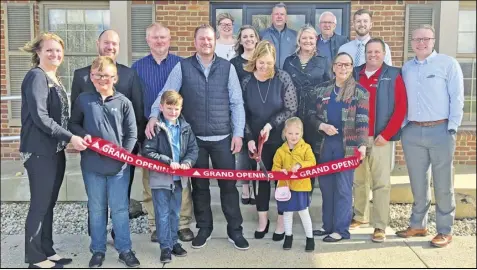  ?? ?? Laura Roetgerman, surrounded by her family, center employees, Minster and county officials, cuts the ‘grand opening’ ribbon on Tuesday evening for the Center for Personal Wellness, located at 4
Eagle Drive in Minster.