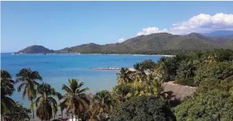  ??  ?? El mar Caribe y la Sierra Maestra siluetean la belleza paisajísti­ca del municipio de Guamá.